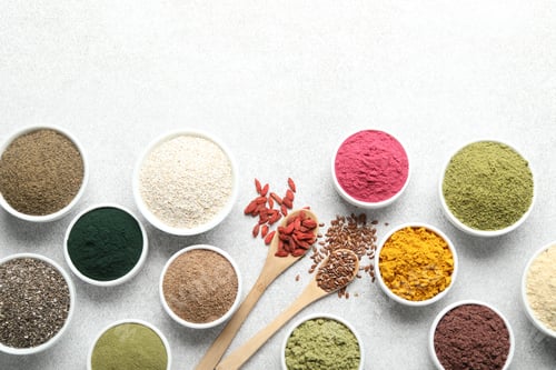 Preview: Different superfood powders on light grey table, flat lay. Space for text