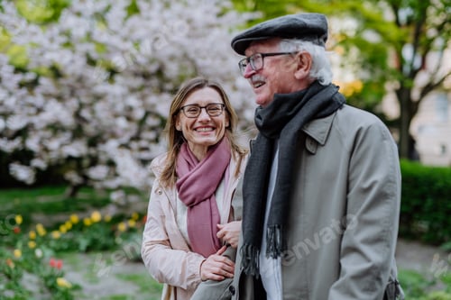 Preview: Happy senior man with adult daughter outdoors on a walk in park.