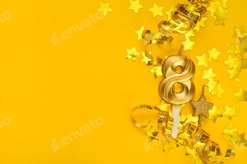 Preview: Gold candle in shape of number eight on yellow background surrounded by stars confetti and streamers