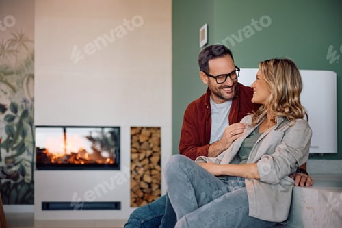 Preview: Happy couple talking while relaxing in their living room.
