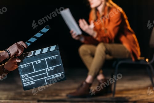 Preview: selective focus of actor with clapboard in front