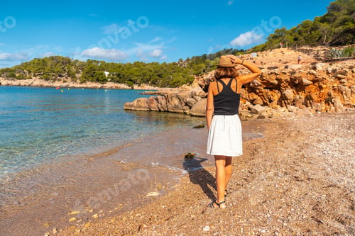 Preview: A young woman on the Salada y Saladeta beach walking enjoying the holidays in Ibiza. Balearic