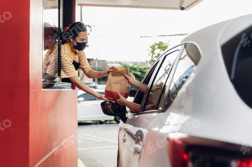 Preview: Hand Man in car receiving coffee in drive thru fast food restaurant