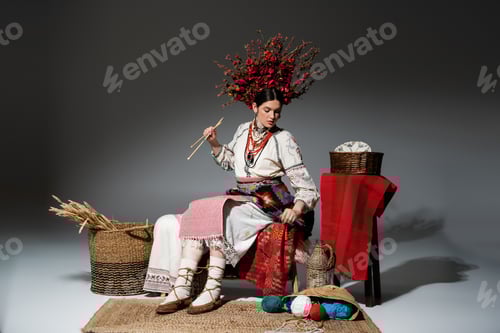 Preview: full length of young ukrainian woman in traditional clothes and red wreath with flowers holding