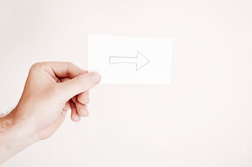 Preview: Photo of a hand holding a drawing of an arrow on white background