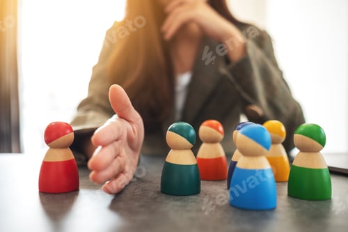Preview: Concept image of a business woman separate wooden people into two group