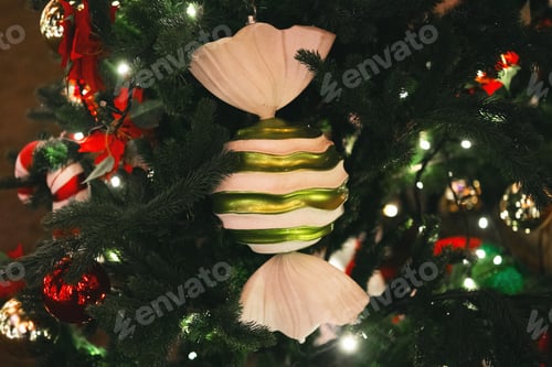 Preview: Close up of decorated evergreen tree with striped candy ornament and lights
