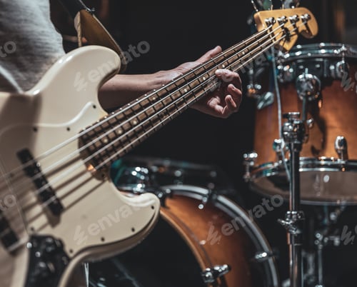 Preview: A man plays the bass guitar on a blurred background with bokeh.