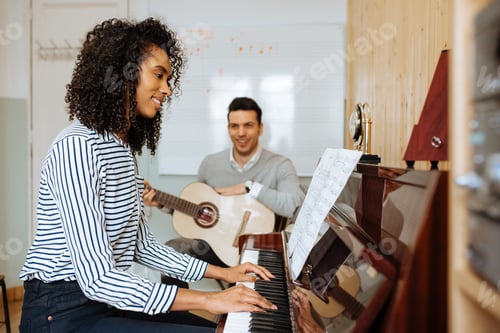 Preview: Woman playing piano near man playing guitar in studio