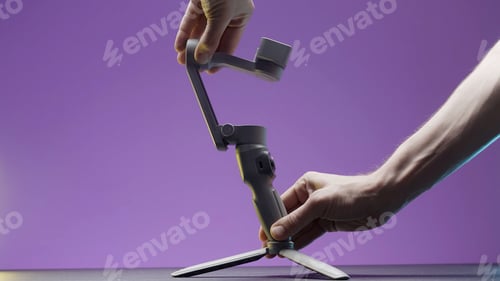 Preview: Portable video camera or smartphone electronic stabilizing system. Action. Close up of male hands