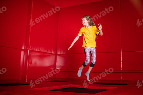 Preview: Child having fun while jumping on trampoline in fitness center