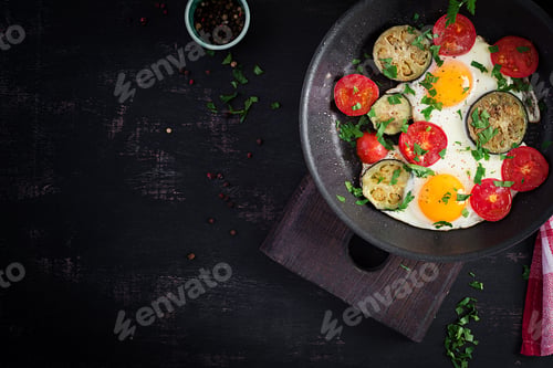 Preview: English breakfast - fried eggs, tomatoes and eggplant. American food. Top view, overhead, copy space