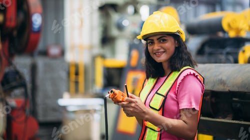 Preview: Portrait of industrial worker inspecting and check up machine at factory machines.