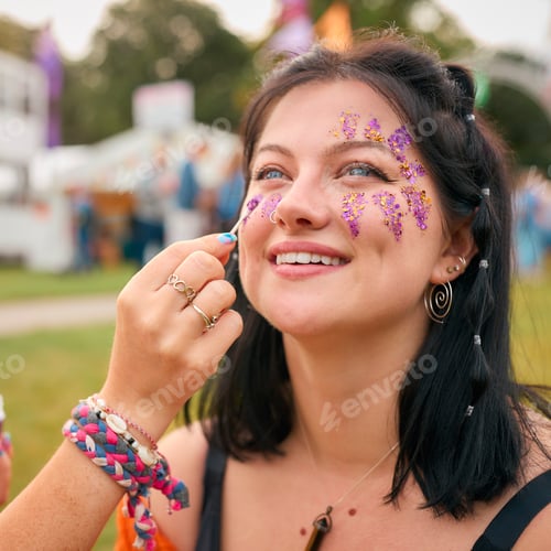 Preview: Two Female Friends Decorating Faces With Glitter At Summer Music Festival