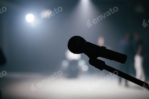 Preview: A close up of a microphone. The silhouette shows the mic on the stand. It is ready for the singer.