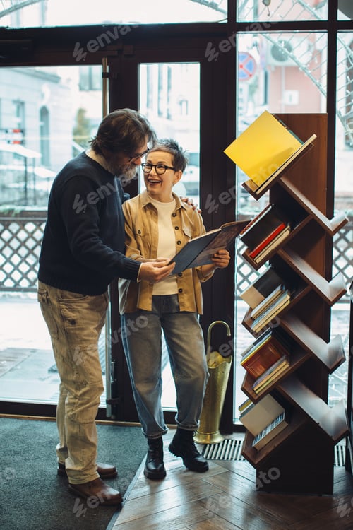 Preview: Mature couple enjoying book shopping together at store
