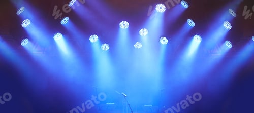 Preview: A stage at a music festival with lights streaming down from above