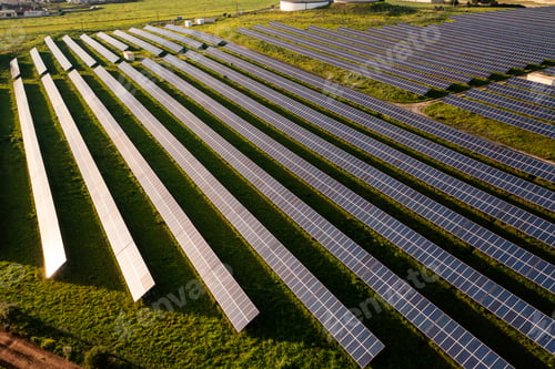 Preview: Drone view of solar panels on green agricultural landscape during day