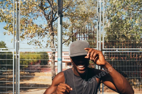 Preview: African man with cap on the street smiling