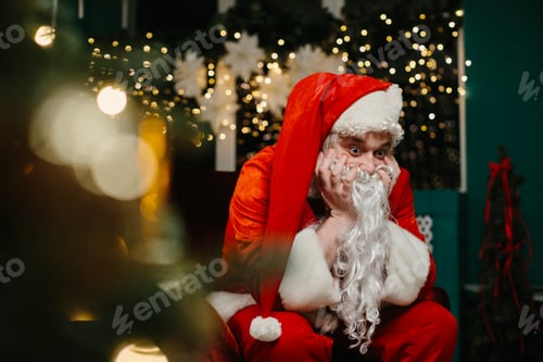 Preview: Bored santa claus resting chin on hands near christmas tree
