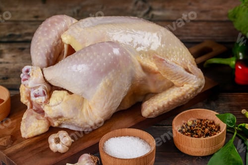 Preview: Raw chicken is placed on cutting board ready for cooking.