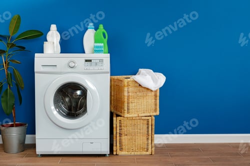 Preview: Washing machine with laundry on blue wall background