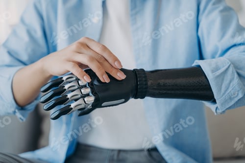 Preview: Cyber hand of female amputee. Disabled woman is changing settings of robotic prosthesis.