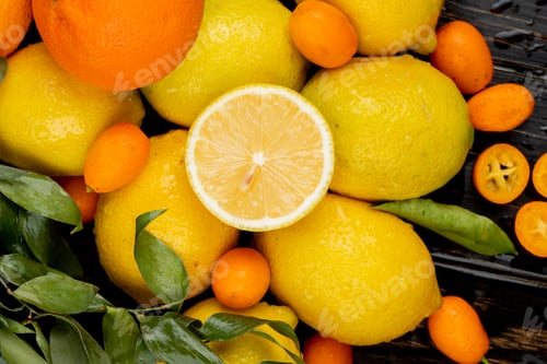 Preview: top view of fresh ripe lemons and kumquat on black background