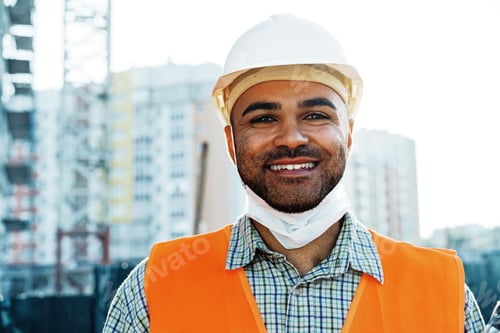 Preview: Portrait of mixed race man builder in workwear and hardhat wearing medical mask, close up
