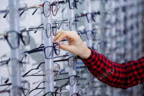Preview: Row of glasses at an opticians. Eyeglasses shop. Stand with glasses in the store of optics.