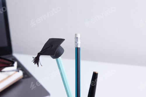 Preview: A cap on a pencil on the background of a desktop with office supplies. Online home learning concept