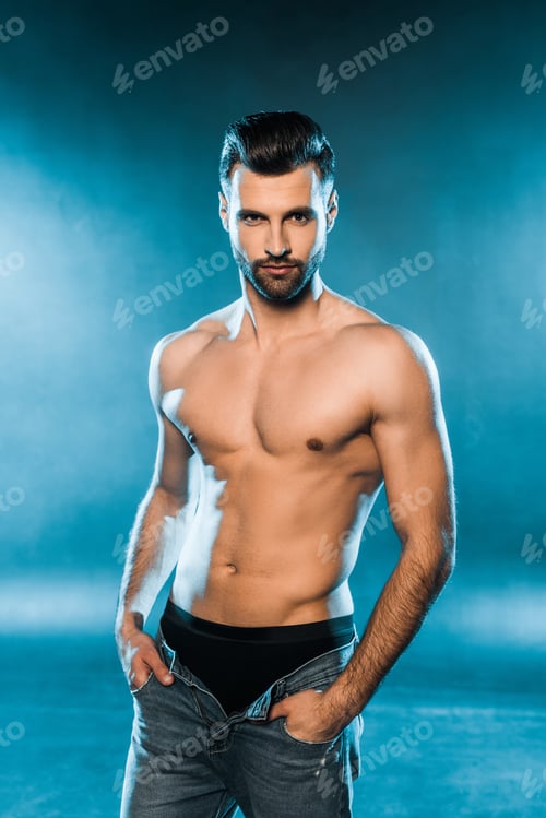 Preview: handsome muscular man in black underwear and jeans posing on blue smoky background