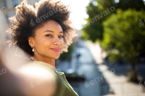Preview: Beautiful young african american woman taking selfie outside