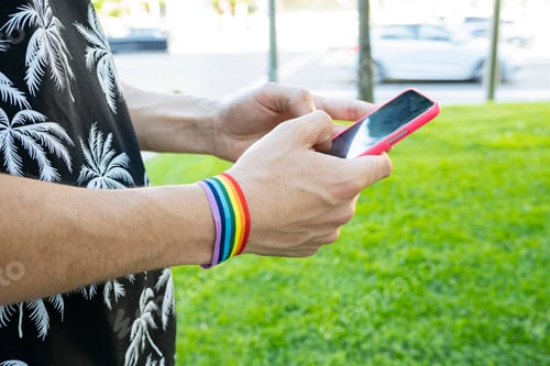 Preview: hands chatting in a park wearing lgbt bracelet