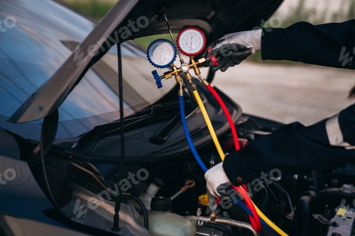Preview: Close up hand of Mechanics inspect and check the refrigerant and fill the car air conditioner.