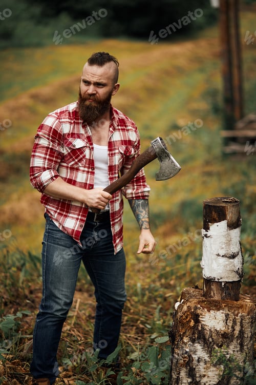 Preview: Woodcutter in shirt chopping firewoods, chips fly apart
