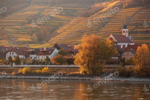 Preview: autumn view of small austrian village on a river bank