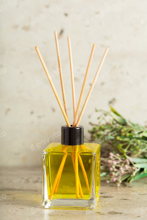 Preview: Elegant aroma diffuser with natural reeds and olive green liquid on a neutral background