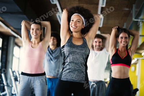 Preview: Group of healthy fit people at the gym exercising
