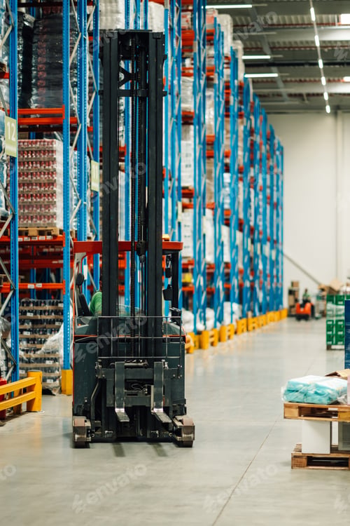 Preview: Forklift parked in a large warehouse with high shelves full of goods