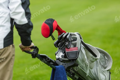 Preview: Golf Bag with Clubs and Player on Green Field Closeup Outdoor Sports Equipment, Training Tournament