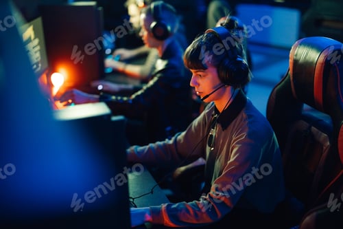 Preview: Female gamer playing multiplayer video game with her friends in a gaming club