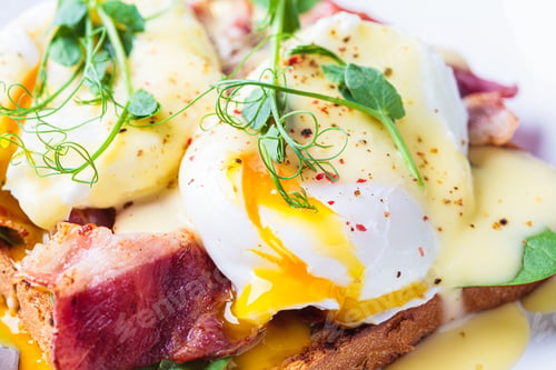 Preview: Eggs benedict on crispy toast with bacon and traditional hollandaise sauce.
