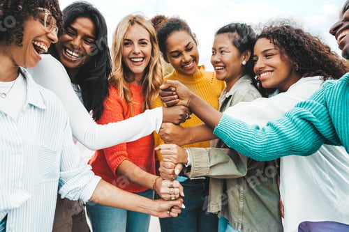 Preview: Multicultural group of women stacking hands together