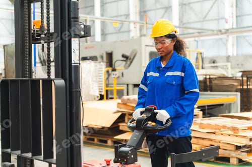 Preview: African American female worker driving forklift truck in heavy metal industrial factory