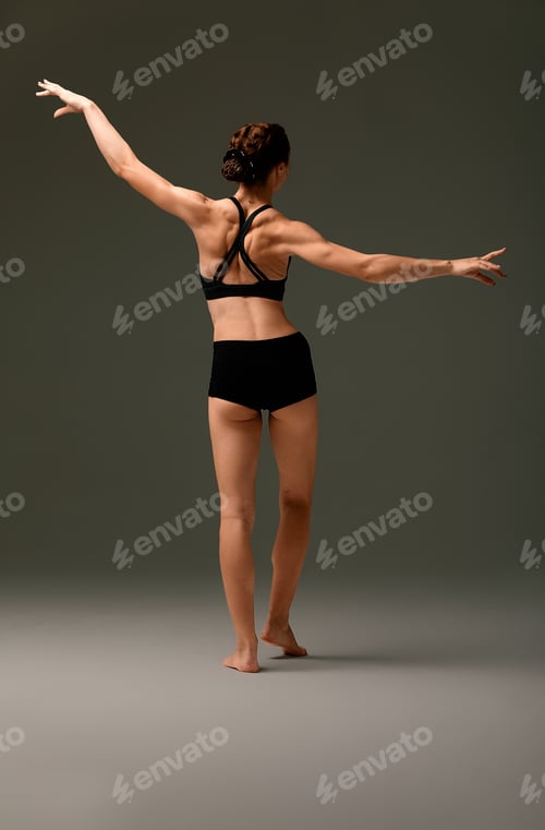 Preview: beautiful woman ballet dancer in black swimsuit posing on light grey studio background. Animal