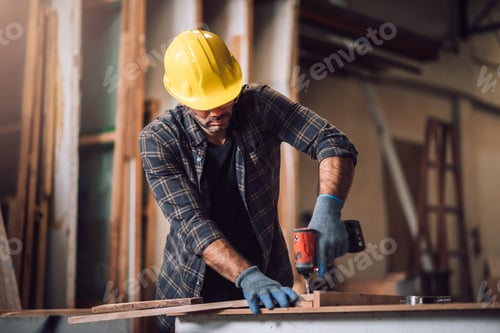 Preview: Young adult men carpenter craftman working in small business wood workshop.