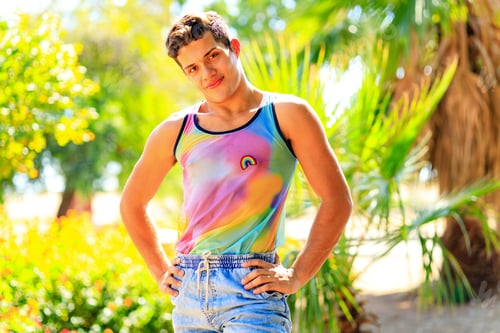 Preview: Handsome man in colorful shirt with rainbow badge outdoor