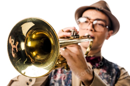 Preview: selective focus of mixed race male musician in stylish hat and eyeglasses playing on trumpet