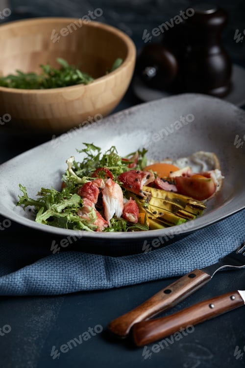 Preview: Salad with crab and avocado on a dark background. Arugula salad leaves seasoned with sauce on white